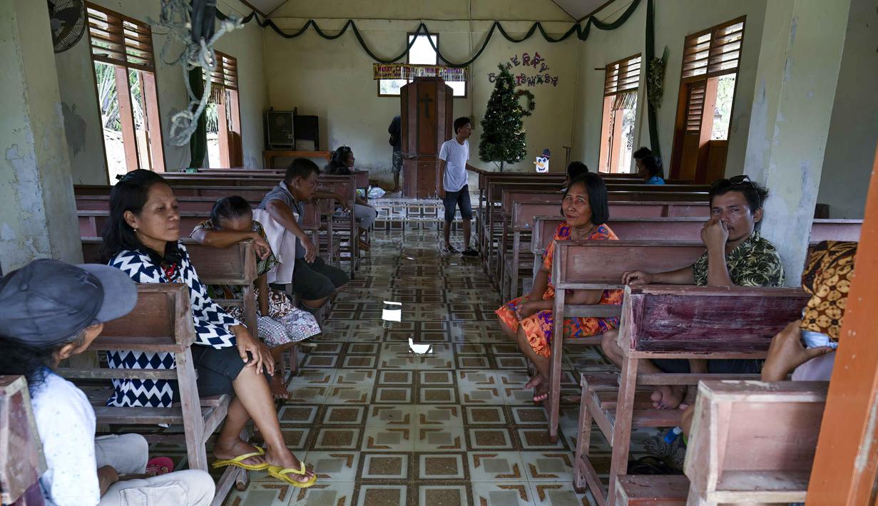 Ribuan rumah warga di wilayah tersebut dilaporkan rusak parah dan nyaris hilang terbenam lumpur. Tampak dalam foto, warga desa beristirahat di dalam gereja yang selamat dari banjir bandang di Desa Aek Garoga, Tapanuli Selatan, Sumatera Utara, pada Sabtu 27 Desember 2025. (YT Hariono /AFP)