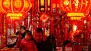 Orang-orang berbelanja dekorasi kemakmuran di sebuah stan untuk menyambut Tahun Baru Imlek, di sebuah Bazaar, Beijing, China, Minggu 1 Februari 2026. (AP Photo/Andy Wong)