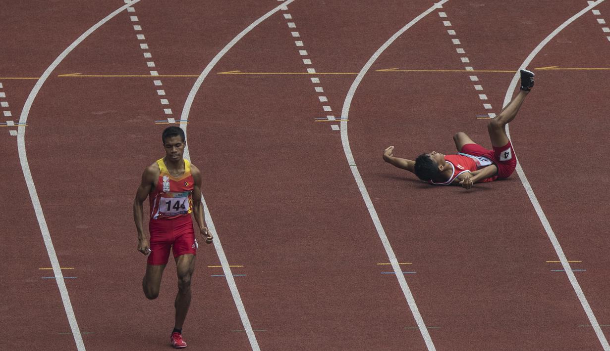 Pelari Indonesia, Sapto Yogo Purnomo, terjatuh saat tanding pada Asian Para Games cabang atletik nomor lari 400 meter T37 di SUGBK, Jakarta, Rabu (10/10). (Bola.com/Vitalis Yogi Trisna)
