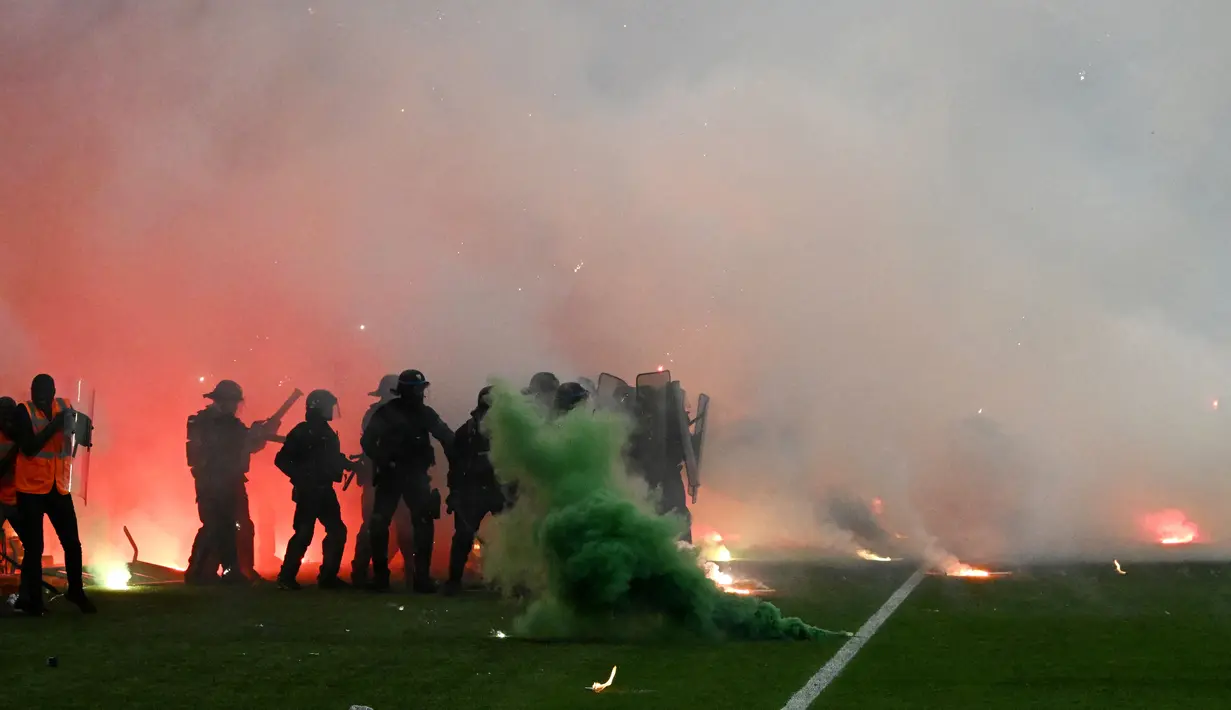 Tak hanya itu, para suporter juga mencoba untuk membakar bangku-bangku di tribun. Polisi anti-huru-hara dan pemadam kebakaran kemudian dikerahkan untuk meredam kerusuhan tersebut. (AFP/Jean-Philippe Ksiazek)