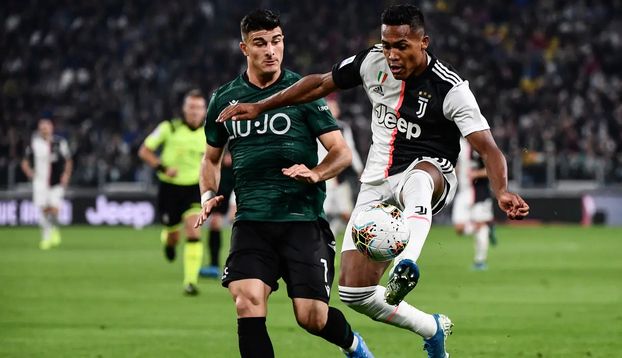 Bek Juventus, Douglas Costa (kanan) berusaha mengontrol bola dari kawalan pemain Bologna, Riccardo Orsolini selama pertandingan lanjutan Liga Serie A Italia di stadion Allianz, Turin (19/10/2019). Juventus menang tipis atas Bologna 2-1. (AFP Photo/Marco Bertorello)