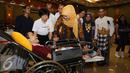Menteri Sosial, Khofifah Indar Parawansa berkomunikasi dengan salah satu penyandang disabiltas di Jakarta, Senin (28/12/2015). Mensos memberikan bantuan sejumlah fasilitas penunjang bagi penyandang disabilitas. (Liputan6.com/Helmi Fithriansyah)