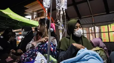 Pasien dievakuasi ke tenda darurat yang didirikan di luar RSUD Sumedang setelah atap dan dinding rusak akibat gempa magnitudo 4,8 di Sumedang, Jawa Barat, Senin (1/1/2024). (Timur MATAHARI/AFP)