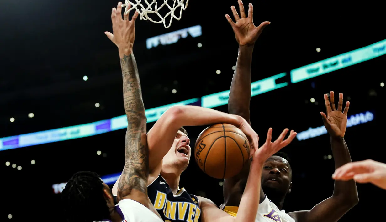 Pemain Denver Nuggets, Nikola Jokic (tengah) gagal melewati adangan para pemain Los Angeles Lakers pada laga NBA basketball game di Staples Center, Los Angeles, (19/11/2017). Lakers menang 127-109. (AP/Ringo H.W. Chiu)