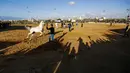 Sejumlah warga Palestina saat mengabadikan aksi koboi saat mengikuti ajang Arabian Horse Show di Kota Gaza, Palestina (3/3). (AFP Photo / Mohammed Abed)
