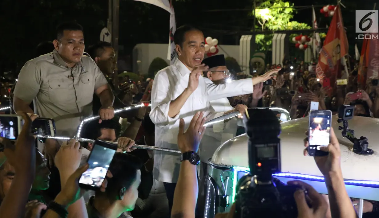 Calon Presiden RI Petahana, Joko Widodo bersama Cawapres Ma’ruf Amin menyapa pendukungnya saat berada di atas jeep menuju gedung KPU dari Tugu Proklamasi, Jakarta, Jumat (21/9). (Liputan6.com/Helmi Fithriansyah)