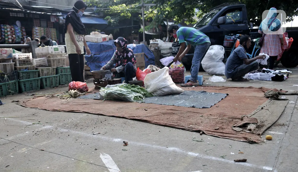 Aktivitas perdagangan dengan menerapkan physical distancing  di halaman Pasar Perumnas Klender, Jakarta, Kamis (18/6/2020). Selain sistem ganjil genap kios, pengelola pasar menerapkan physical distancing antarlapak untuk mencegah penularan COVID-19. (merdeka.com/Iqbal S. Nugroho)
