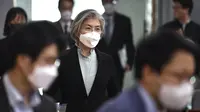 Menteri Luar Negeri Korea Selatan Kang Kyung-wha (tengah) mengenakan masker tiba untuk menghadiri konferensi untuk diplomat asing tentang situasi wabah virus corona di Korea, di kementerian luar negeri di Seoul, Jumat (6/3/2020). (Jung Yeon-je/Pool Photo via AP)