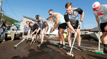 Para pemain rugby Kanada secara sukarela membersihkan jalan usai terjadi Topan Hagibis di Kamaishi, Prefektur Iwate, Jepang, Minggu (13/10/2019). Topan Hagibis membuat pertandingan Rugby World Cup Pool B antara Kanada dengan Namibia dibatalkan. (Kyodo News via AP)