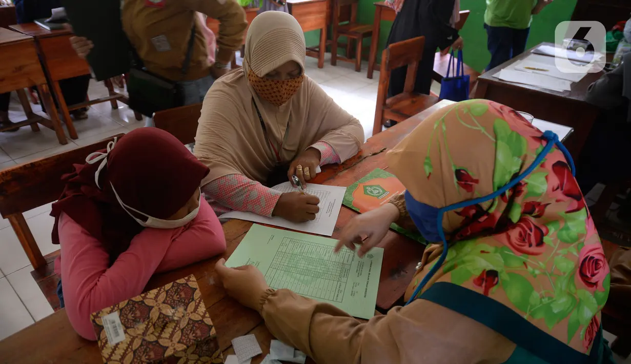 Siswa Sekolah SD kelas 4,5 dan 6 didampingi wali murid sedang mengambil rapot secara bergilir di Sekolah Islam Raudlatul Hikmah, Parakan, Pondok Benda, Pamulang, Tangerang Selatan, Banten, Jumat (16/10/2020).  (merdeka.com/Dwi Narwoko)