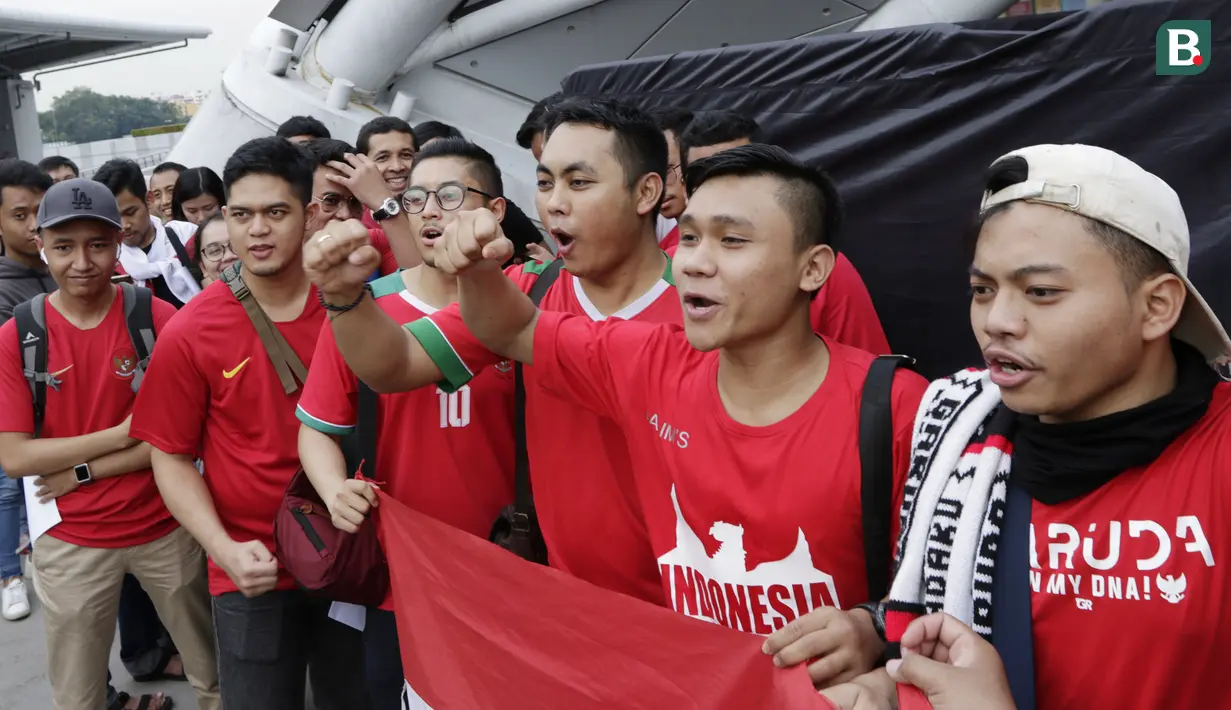 Suporter Timnas Indonesia menyanyikan lagu saat berada di Stadion Nasional, Singapura, Jumat (9/11). Indonesia akan melawan Singapura pada laga Piala AFF 2018. (Bola.com/M. Iqbal Ichsan)