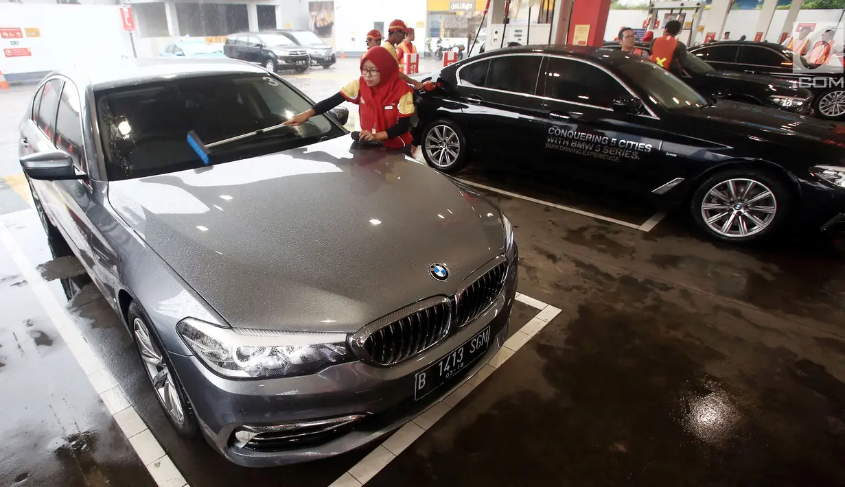 Petugas membersihkan kaca saat pengisian BBM Shell V-Power ke mobil BMW 520i Luxury dalam acara flag off di SPBU Shell Gatot Subroto, Jakarta, Senin (12/3). Program BMW Driving Experience adalah kegiatan menempuh lima kota besar. (Merdeka.com/Dwi Narwoko)