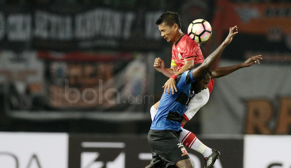 Aksi pemain Persija Jakarta, Ismet sofyan berebut bola dengan pemain Madura United, Engelberd Sani pada lanjutan Liga 1 2017 di Stadion Patriot, Bekasi, Kamis (4/5/2017). (Bola.com/Nicklas Hanoatubun)