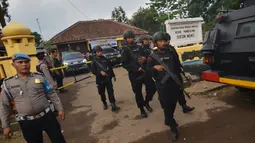 Polisi berjaga di lokasi penusukan Menkopolhukam Wiranto di Pandeglang, provinsi Banten (10/10/2019). Kepala Badan Intelijen Negara (BIN) Budi Gunawan menyatakan, penusuk Wiranto merupakan afiliasi Jamaah Ansharut Daulah (JAD). (AFP/Ronald Siagian)