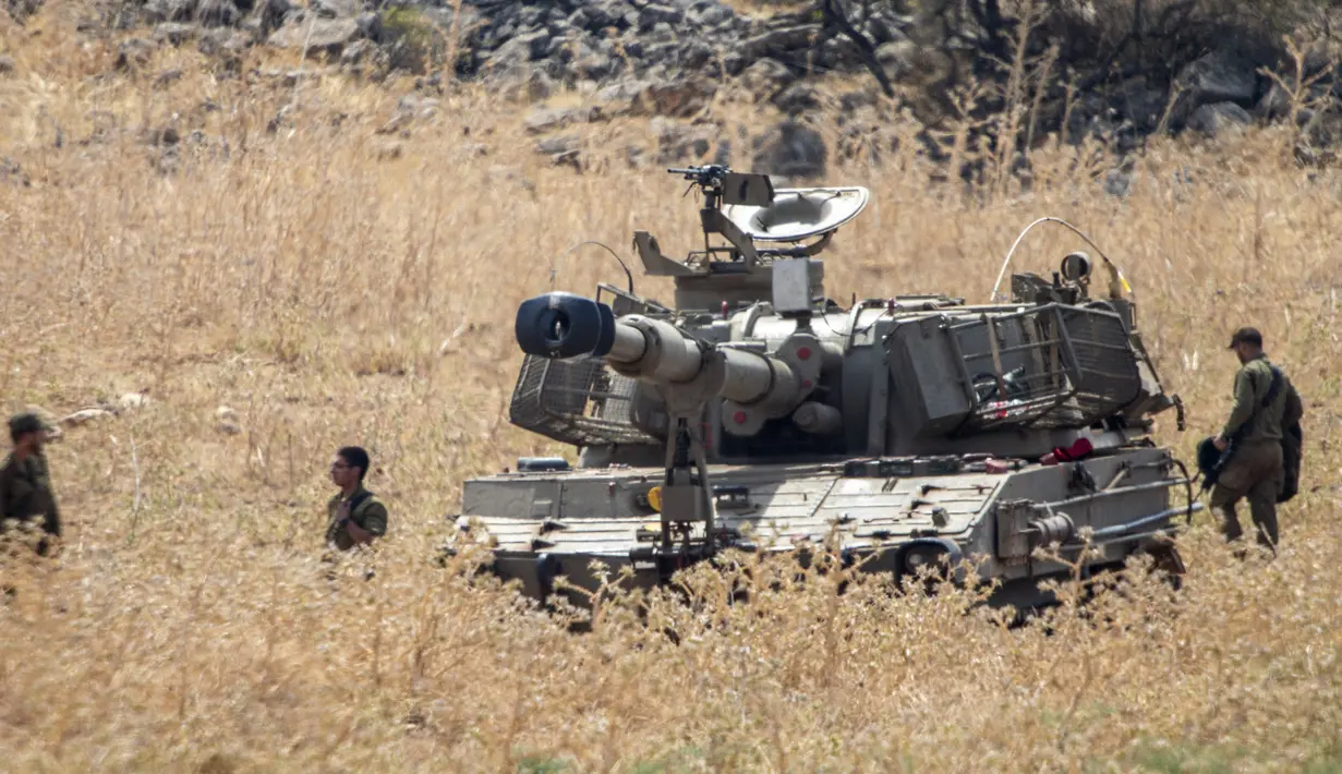 Tentara Israel berdiri di sekitar unit artileri bergerak yang ditempatkan dekat perbatasan dengan Lebanon di Israel utara, Selasa (28/7/2020). Situasi perbatasan Israel dengan Lebanon memburuk setelah meningkatnya ketegangan antara kedua negara. (AP Photo/Ariel Schalit)