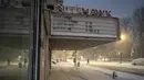 Badan Layanan Cuaca Nasional (NWS) melaporkan intensitas salju yang turun sangat ekstrem, mencapai lima hingga tujuh sentimeter per jam. Tampak dalam foto, seorang pelari berlari melewati Nitehawk Cinema di distrik Brooklyn, Kota New York, sebelum matahari terbit pada Senin 23 Februari 2026. (Jeremy Weine/Getty Images North America/Getty Images via AFP)