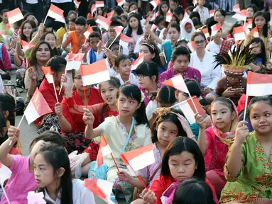 Ratusan anak-anak mengibarkan bendera Merah Putih saat gelaran Harmoni Indonesia 2018 di Kompleks Gelora Bung Karno, Jakarta, Minggu (5/8). Presiden RI, Joko Widodo hadir dalam acara tersebut. (Liputan6.com/Helmi Fithriansyah)