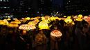 Umat Buddha Korea Selatan mengenakan masker membawa lentera lotus berwarna-warni selama upacara pencahayaan untuk merayakan ulang tahun Buddha yang akan datang pada 8 Mei, di Seoul, Korea Selatan (5/4/2022). (AP Photo/Lee Jin-man)