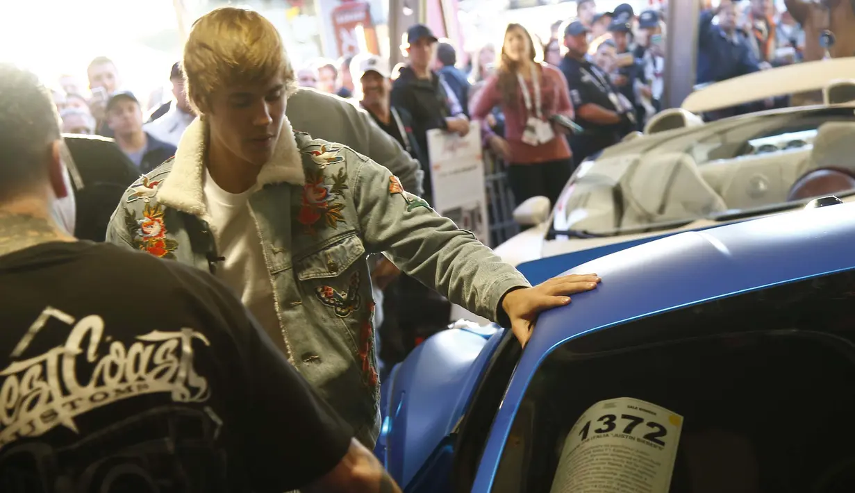 Justin Bieber saat melelang mobil Ferrari 458 Italia miliknya di Barrett-Jackson di Westworld di Scottsdale, Arizona, AS (21/1). Dilansir Female First, Justin akan menyumbangkan semua uang hasil lelang tersebut. (Patrick Breen/The Arizona Republic via AP)