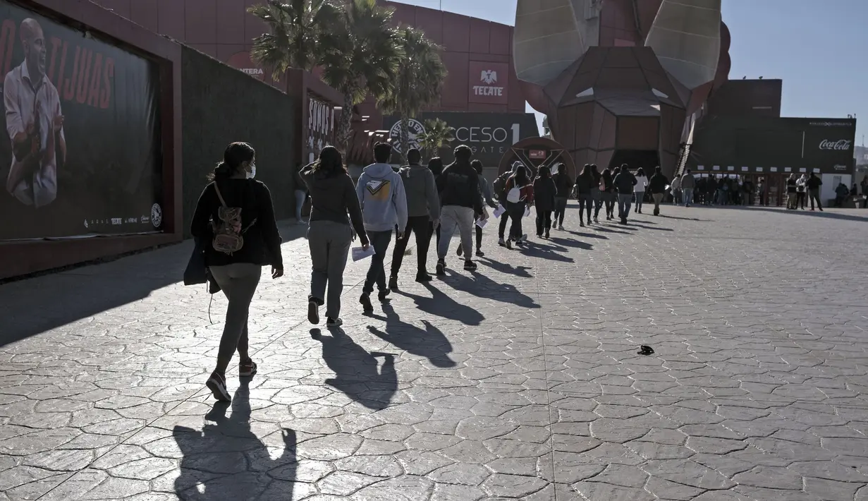 Anak-anak mengantre untuk divaksin COVID-19 dalam program vaksinasi untuk anak-anak berusia 15 hingga 17 tahun di Stadion Caliente, Tijuana, Baja California, Meksiko, 24 November 2021. Meksiko bersiap menghadapi gelombang keempat infeksi virus corona COVID-19. (Guillermo Arias/AFP)