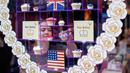 Karyawan menata cupcakes edisi khusus untuk menghormati pernikahan Pangeran Harry dan Meghan Markle di Hummingbird Bakery, London, 11 Mei 2018. Pernikahan Harry dan Meghan digelar 19 Mei mendatang di Kapel St. George, Istana Windsor. (AFP/Tolga AKMEN)