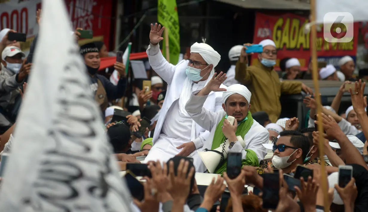 Rizieq Shihab menyapa massa pendukungnya saat tiba di kediamannya di Jalan Petamburan, Jakarta, Selasa (10/11/2020). Rizieq Shihab tiba di kediamannya usai pulang dari Arab Saudi. (merdeka.com/Imam Buhori)