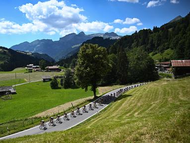 Rombongan pebalap melintas dengan latar belakang pegunungan Alpen Swiss selama etape ke-8 pada ajang balapan sepeda Tour de France 2022. (AFP/Anne-Christine Poujoulat)