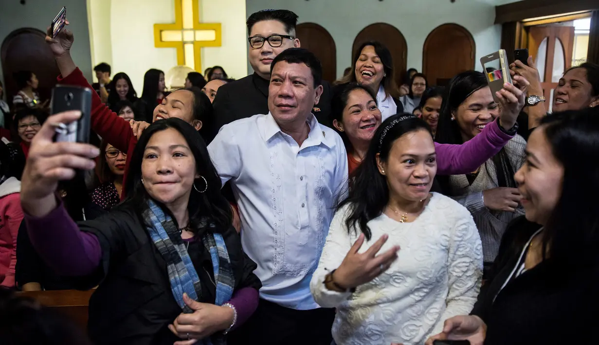 Peniru Presiden Filipina Rodrigo Duterte, Cresencio Extreme ditemani peniru pemimpin Korea Utara Kim Jong Un, Howard X menghadiri kebaktian gereja di Hong Kong, 3 Februari 2019. Kunjungan tak terduga keduanya membuat heboh Hong Kong (ISAAC LAWRENCE/AFP)