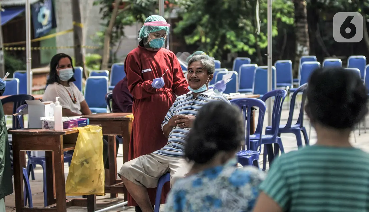 Warga menjalani tes usap PCR di Taman Pintar, Kayu Putih, Pulogadung, Jakarta Timur, Selasa (8/6/2021). Saat ini, RW 09 dan 10 Kelurahan Kayu Putih dalam status zona merah atau karantina wilayah sejak 4 Juni setelah 22 orang terkonfirmasi positif COVID-19. (merdeka.com/Iqbal S. Nugroho)