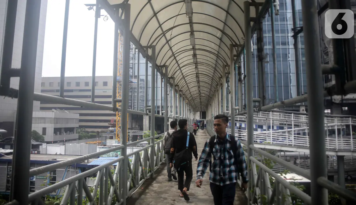 Sejumlah warga melintas di jembatan penyeberangan orang (JPO) dekat Unika Atma Jaya, Jakarta, Rabu (13/11/2019). JPO dekat Unika Atma Jaya dan Hotel Le Meridien di Jalan Jenderal Sudirman akan dicopot karena hanya berhubungan dengan trotoar yang merupakan ruang terbuka. (Liputan6.com/Faizal Fanani)