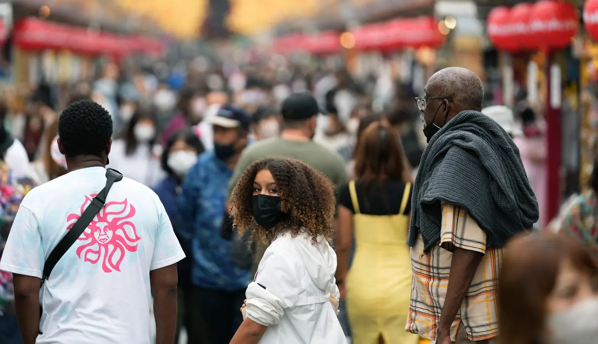 Turis melihat sekeliling saat berjalan di distrik hiburan Asakusa, Tokyo, Jepang, Senin (17/10/2022). Kawasan ini menjadi destinasi wisata yang paling banyak dikunjungi wisatawan asing. (AP Photo/Hiro Komae)