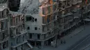 Sejumlah orang berjalan melewati bangunan yang hancur akibat pertempuran di Tariq al-Bab yang dikuasai pemberontak di Aleppo, Suriah, (5/10). (REUTERS/Abdalrhman Ismail)