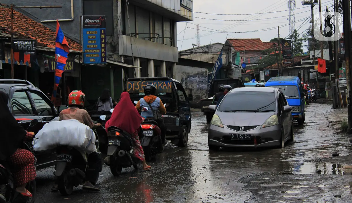 Sejumlah pengendara melintasi jalan berlubang dan tergenang air di Jalan Raya Pabuaran, Citayam, Depok, Rabu (26/2/2020). Kerusakan disebabkan oleh kubangan air yang menggenangi jalan tersebut pada musim hujan  yang melanda Jabodetabek dua bulan terakhir. (merdeka.com/magang/Muhammad Fayyadh)
