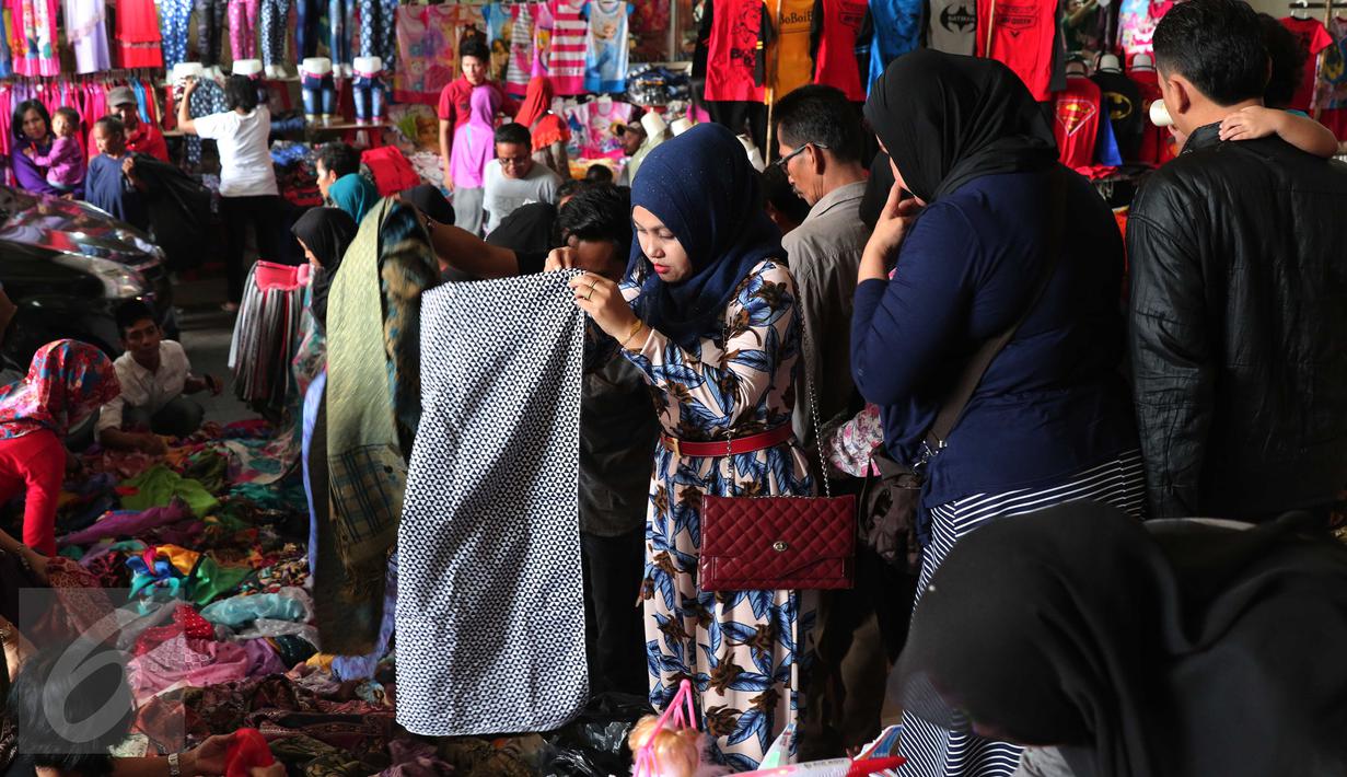 Calon pembeli memilih kerudung saat berbelanja di Pasar Tanah Abang, Jakarta, Rabu (9/12). Libur pilkada dimanfaatkan warga untuk berbelanja pakaian di pasar tekstil terbesar di Asia Tenggara itu. (Liputan6.com/Angga Yuniar)