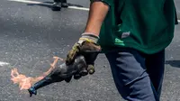 Demonstran bersenjatakan bom molotov saat demonstrasi menentang Presiden Nicolas Maduro di Caracas,  Venezuela, Rabu (26/4). Hingga kini, bentrokan antara demonstran dan polisi telah menyebabkan 26 orang tewas. (AFP PHOTO) 