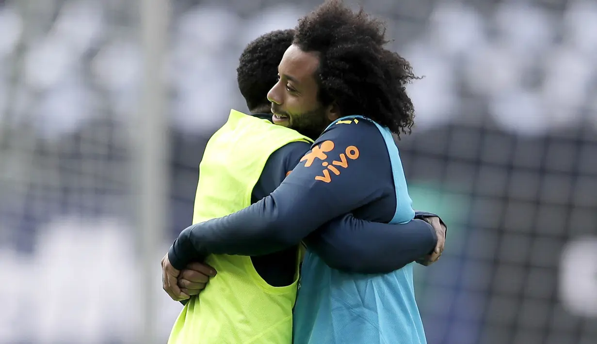 Bek Brasil, Marcelo, memeluk Taison, saat latihan jelang laga persahabatan di Berlin, Jerman, Selasa, (27/3/2018). Brasil akan berhadapan dengan Jerman. (AP/Michael Sohn)