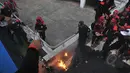 Seorang pria membakar diri dan terjun dari atap stadion Gelora Bung Karno, Jakarta, Jumat (1/5/2015). Sejumlah buruh tampak berusaha memadamkan api dengan air minum. (Liputan6.com/Herman Zakharia)