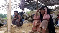 Pengungsi Rohingya duduk di sebuah tenda yang rusak akibat dihantam Topan Mora di sebuah kamp di distrik Cox's Bazar, Bangladesh (31/5). Ribuan rumah dan tenda-tenda yang beratap jerami di kamp tersebut hancur akibat Topan Mora. (AFP Photo/Str)