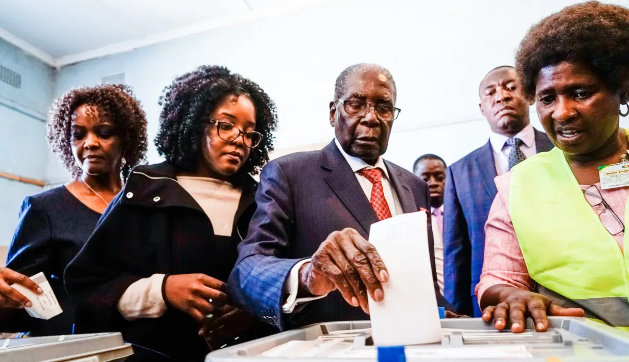 Mantan Presiden Zimbabwe, Robert Mugabe memasukan surat suara dalam pemilihan umum negara itu di TPS distrik Highfield, Harare, Senin (30/7). Mugabe pertama kalinya memberikan suara dalam pemilu, setelah dilengserkan November 2017. (AFP/Zinyange AUNTONY)