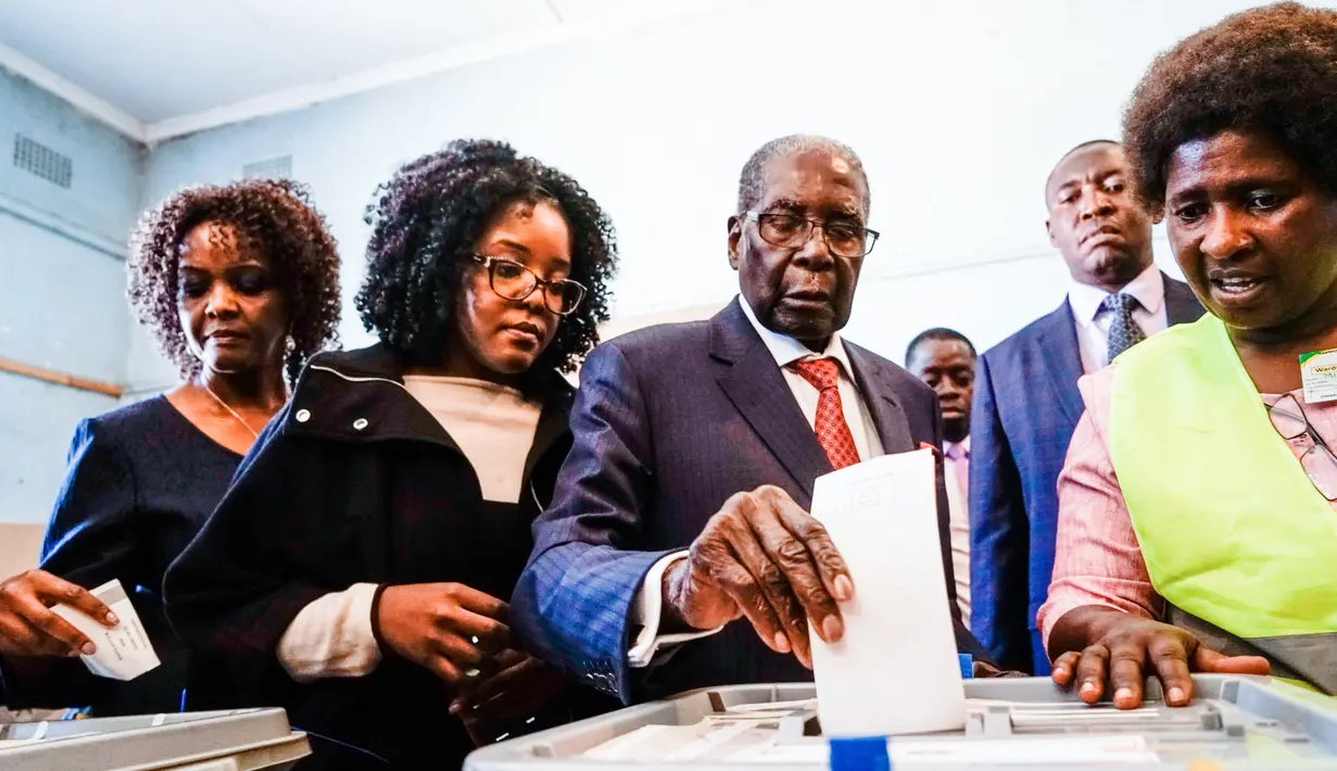 Mantan Presiden Zimbabwe, Robert Mugabe memasukan surat suara dalam pemilihan umum negara itu di TPS distrik Highfield, Harare, Senin (30/7). Mugabe pertama kalinya memberikan suara dalam pemilu, setelah dilengserkan November 2017. (AFP/Zinyange AUNTONY)