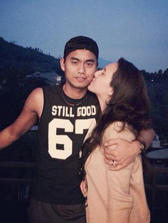Michelle mendaratkan ciuman mesra di pipi Tontowi yang terlihat macho dengan singlet hitam. (Instagram/ michelle_ahmad)
