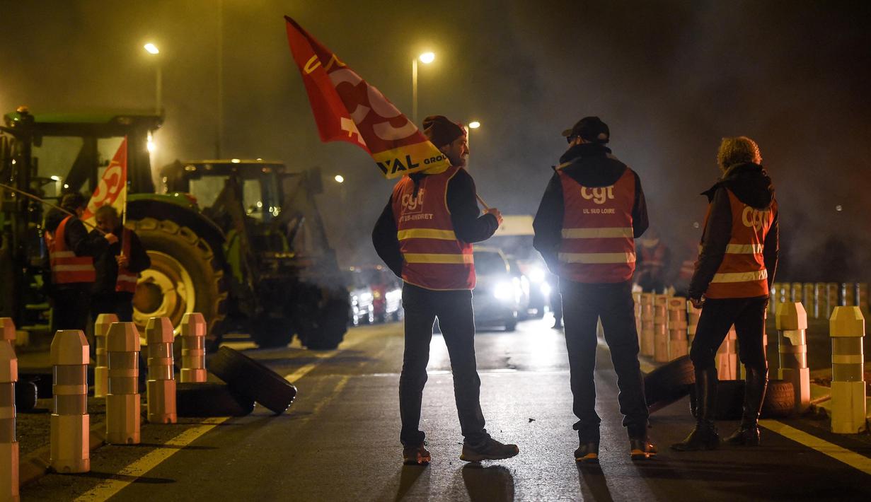 Para anggota serikat pekerja Konfederasi Umum Buruh (CGT) berpartisipasi dalam aksi perlambatan untuk menentang reformasi pensiun, di dekat bandara Nantes di Bouguenais, Prancis barat pada Kamis (16/2/2023). Prancis bersiap-siap menghadapi pemogokan baru dan demonstrasi massal menentang proposal Presiden Prancis untuk mereformasi pensiun Prancis, termasuk menaikkan usia pensiun dari 62 menjadi 64 tahun dan meningkatkan jumlah tahun orang harus memberikan kontribusi untuk mendapatkan pensiun penuh. (Sebastien SALOM-GOMIS/AFP)