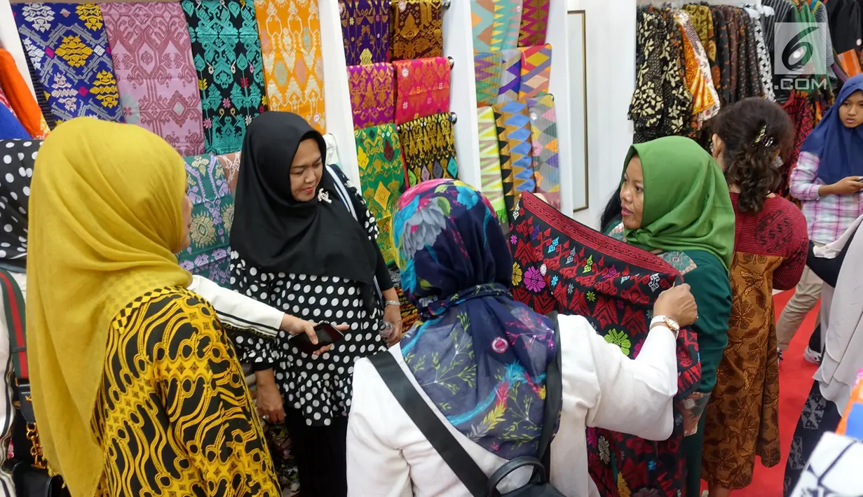 Pengunjung memilih pakaian di Naung Songket yang merupakan binaan Yayasan Dharma Bhakti Astra (YDBA) pada pameran kerajinan INACRAFT 2019 di Jakarta. Sebanyak 8 UKM binaan YDBA telah mengikuti technical meeting serta pelatihan marketing sebagai bekal dalam mengikuti pameran. (Liputan6.com/HO/Eko)