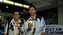 Pebulutangkis ganda putra, Mohammad Ahsan/Hendra Setiawan, memamerkan medali emas Asian Games 2014 sesaat setelah tiba di Bandara Soekarno-Hatta, Selasa (30/9/2014). (Liputan6.com/Helmi Fithriansyah)