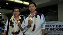 Pebulutangkis ganda putra, Mohammad Ahsan/Hendra Setiawan, memamerkan medali emas Asian Games 2014 sesaat setelah tiba di Bandara Soekarno-Hatta, Selasa (30/9/2014). (Liputan6.com/Helmi Fithriansyah)