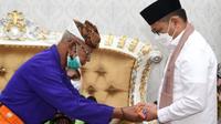Pj Gubernur Gorontalo Hamka Hendra Noer saat menjalani prosesi adat Gorontalo
