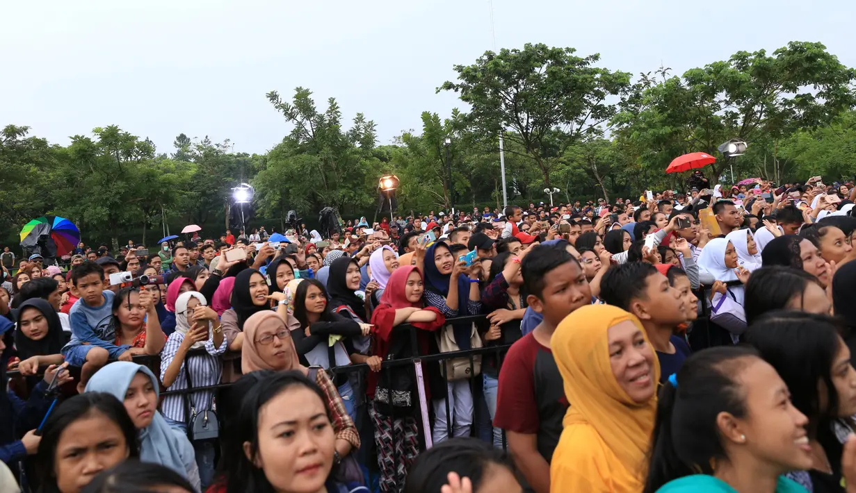Suasana di pelataran Bintaro Xchange, Tangerang Selatan dimana lokasi meet and greet berlangsung sempat diguyur hujan. Seolah mereka tidak menghiraukan guna bisa berdekatan dengan para idolanya. (Adrian Putra/Bintang.com)(Adrian Putra/Bintang.com)