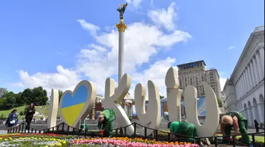 Pekerja menanam bunga di Independence Square menjelang final Liga Champions antara Real Madrid dan Liverpool FC, Kiev, Ukraina, Senin (21/5). Final Liga Champions akan berlangsung pada 26 Mei 2018. (Sergei SUPINSKY/AFP)