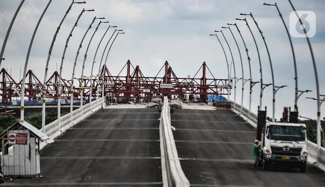 Aktivitas pekerja saat menyelesaikan proyek pembangunan jalur lintas atas (flyover) Cakung, Jakarta, Kamis (17/12/2020). Proyek Flyover Cakung saat ini telah mencapai 94 persen dan sedang menyelesaikan pemasangan balok girder pada bentang yang melintasi rel kereta api. (merdeka.com/Iqbal Nugroho)