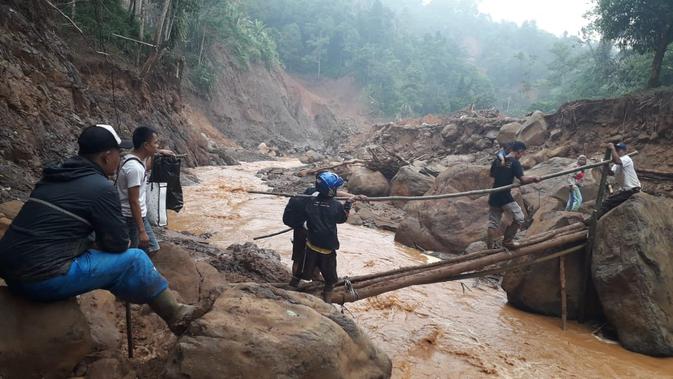 Relawan mendistribusikan logistik dengan akses terbatas untuk korban longsor di Kecamatan Sukajaya, Bogor. (Achmad Sudarno/Liputan6.com)